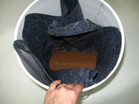 Add 1st coco coir brick to fabric container in bucket